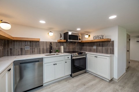 a kitchen with stainless steel appliances and white cabinets